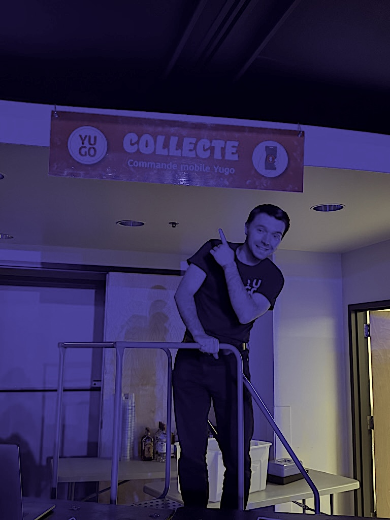 A Yugo cofounder installing the Yugo banner with a ladder